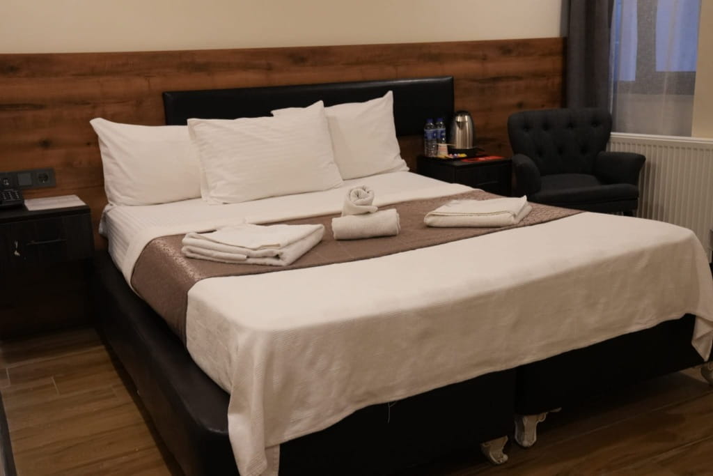 Çiftler için konforlu yatak ve şehir manzaralı Deta Port Hotel double oda.